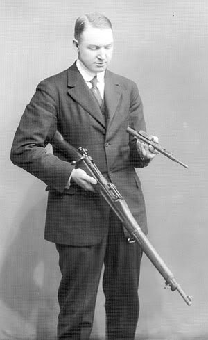 레밍턴 모델 10의 설계자인 존 페더슨. 왼손에 M1903 볼트액션을 반자동 소총으로 만들어주는 페더슨 디바이스를 들고 있다. <출처: Public Domain>