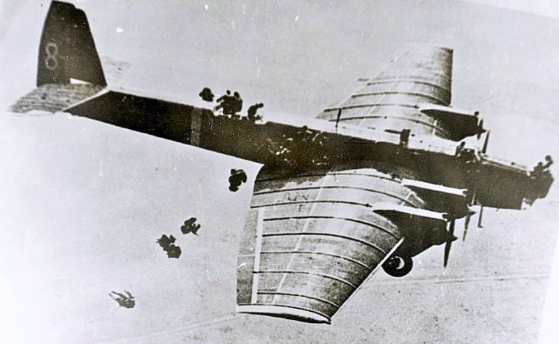 비행 중 기체 밖으로 나와 주익 위로 옮겨 간 후 낙하하는 방식으로 공수부대원들을 투하하는 모습. < 출처 : Public Domain >