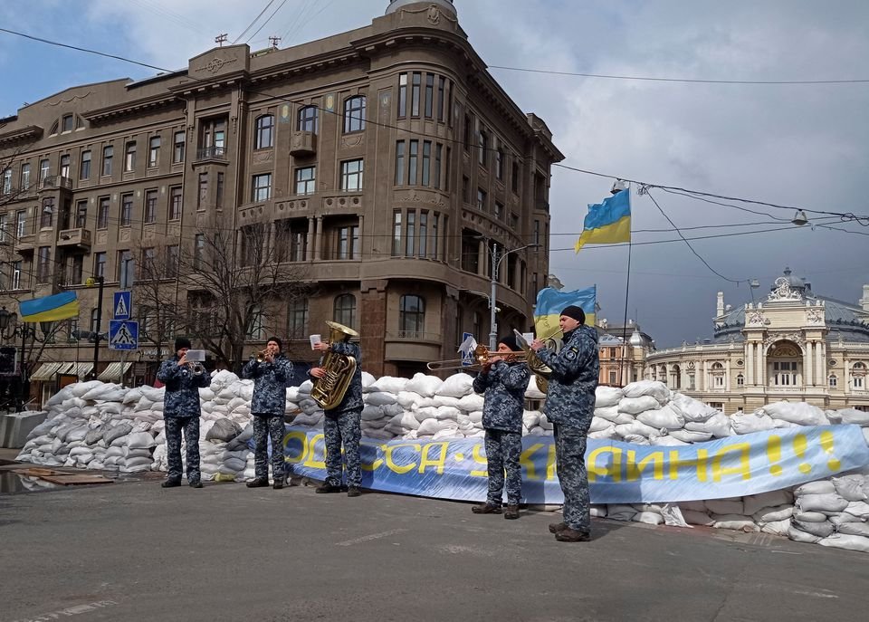 3월 9일, 우크라이나 남부 항구인 오데사(Odessa) 시민군들은 모래주머니를 쌓아 도로를 차단했다. 그 앞에서 우크라이나 해군 밴드가 ‘Don’t Worry, Be Happy‘를 연주하고 있다. <출처: https://www.reuters.com/world/europe/dont-worry-be-happy-behind-sandbags-odessa-waits-see-if-its-next-2022-03-08/>